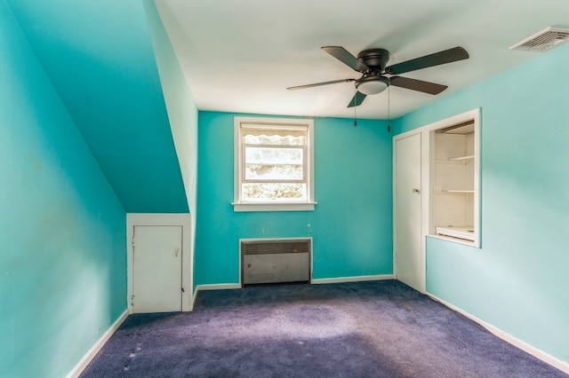 interior space featuring a closet, ceiling fan, radiator heating unit, and dark colored carpet