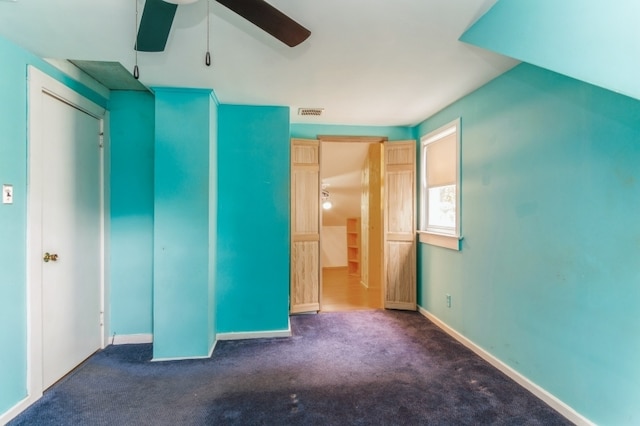 unfurnished bedroom featuring ceiling fan, a closet, and dark colored carpet