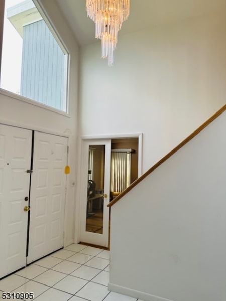 tiled foyer entrance with a chandelier