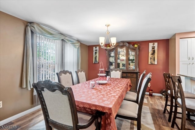 dining room with hardwood / wood-style flooring and a chandelier