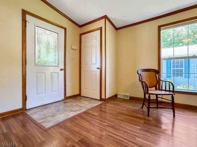 foyer featuring crown molding and hardwood / wood-style floors