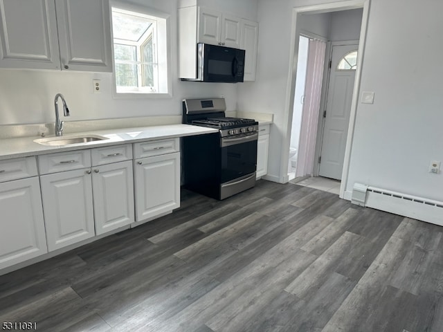 kitchen with gas range, dark hardwood / wood-style floors, sink, white cabinetry, and baseboard heating