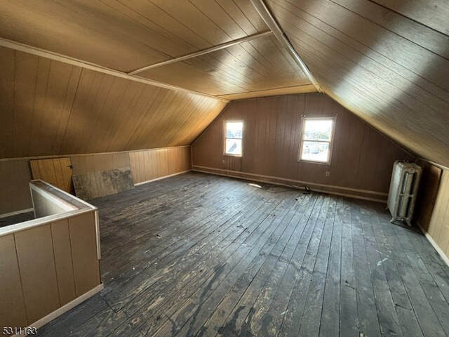 additional living space with wood ceiling, lofted ceiling, hardwood / wood-style floors, and wood walls