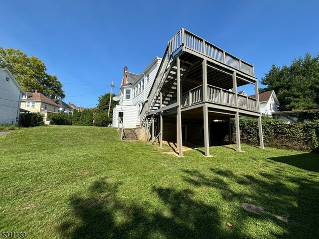 rear view of property with a lawn and a wooden deck