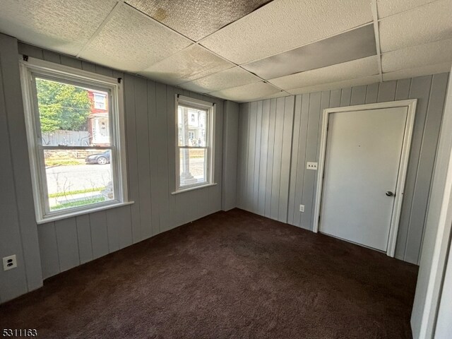 carpeted spare room with a paneled ceiling