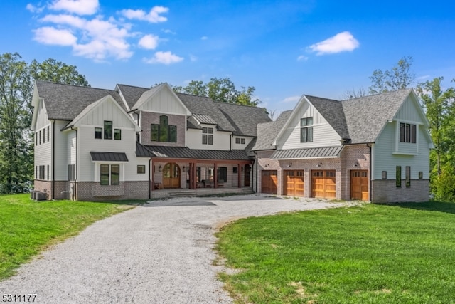 modern farmhouse style home featuring cooling unit, a front lawn, and a garage