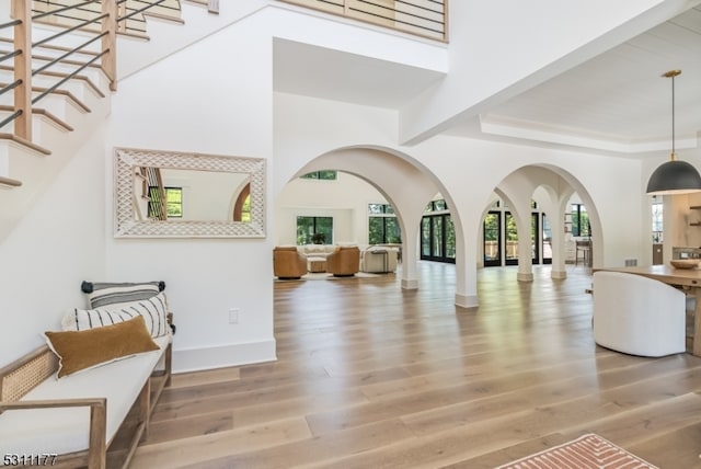 entryway with ornate columns, a high ceiling, and hardwood / wood-style floors