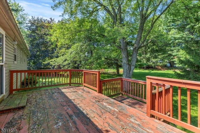 wooden deck featuring a lawn