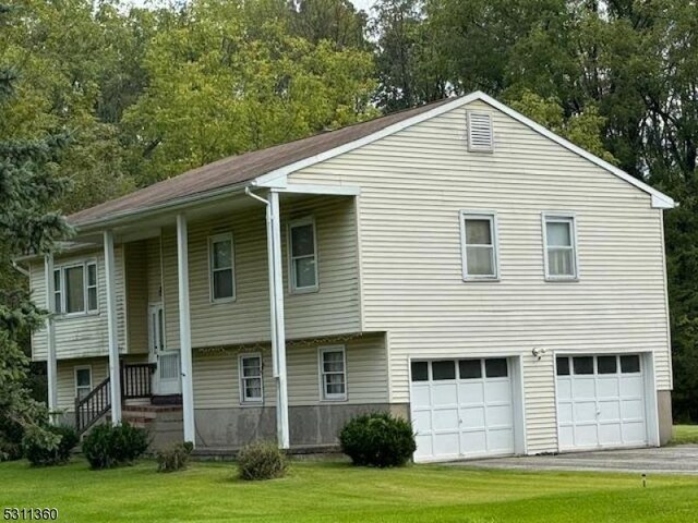 raised ranch with a garage and a front yard