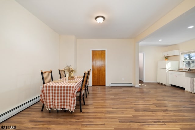 dining area with wood-type flooring and baseboard heating