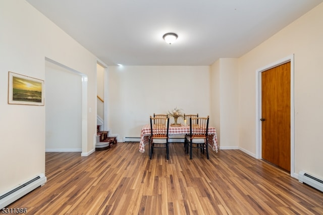 dining area with dark wood-type flooring and a baseboard radiator