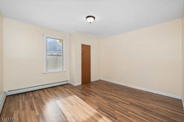 empty room with wood-type flooring and baseboard heating