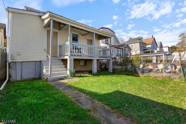 back of property with a yard, covered porch, and a garage