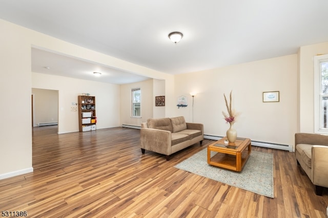 living room featuring a baseboard heating unit and hardwood / wood-style flooring