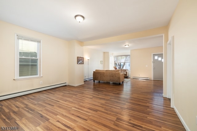 interior space featuring hardwood / wood-style floors, a baseboard heating unit, and a wealth of natural light