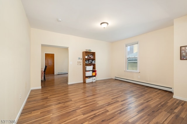 empty room featuring dark hardwood / wood-style floors and baseboard heating