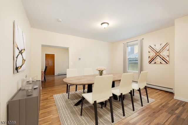 dining room featuring baseboard heating and hardwood / wood-style floors