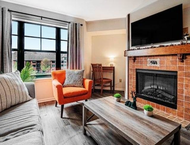 living room featuring a tiled fireplace and hardwood / wood-style floors