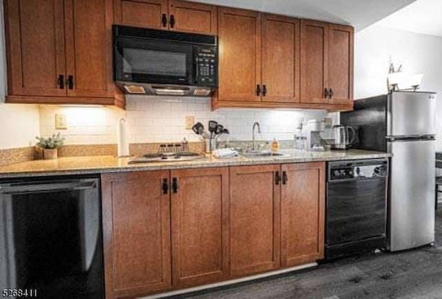 kitchen featuring decorative backsplash, brown cabinets, a sink, and black appliances