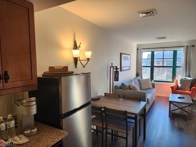 interior space featuring stainless steel refrigerator and dark hardwood / wood-style floors