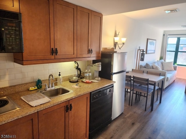 kitchen with black appliances, sink, decorative backsplash, and dark hardwood / wood-style floors