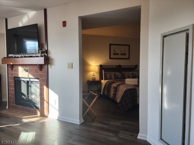 bedroom featuring a fireplace and dark hardwood / wood-style flooring