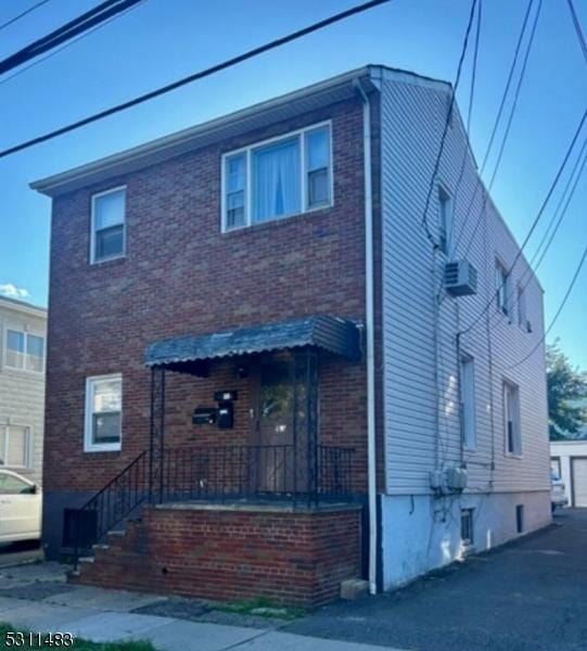 view of front of house with an outdoor structure, a garage, and brick siding