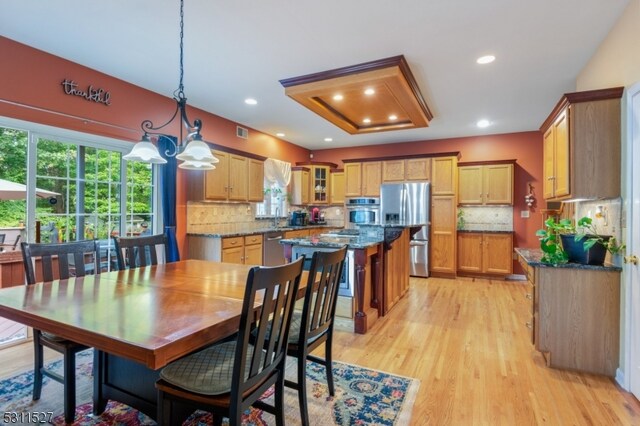 dining area with a notable chandelier and light wood-type flooring