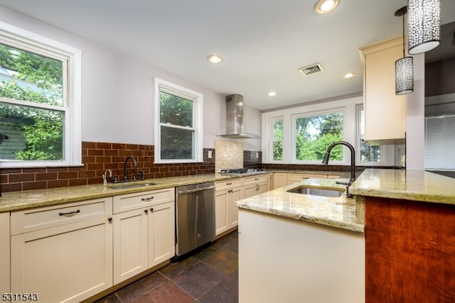 kitchen featuring pendant lighting, stainless steel appliances, sink, and wall chimney range hood