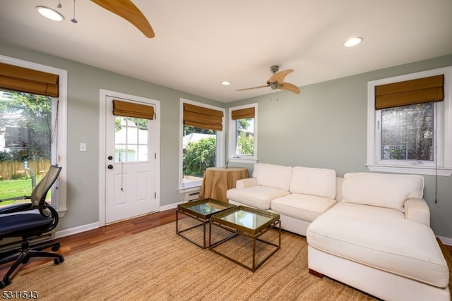 living room featuring plenty of natural light, ceiling fan, and light wood-type flooring