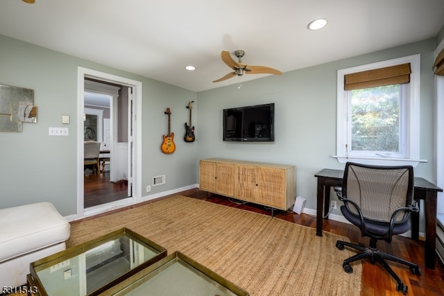 living room featuring ceiling fan and dark hardwood / wood-style floors