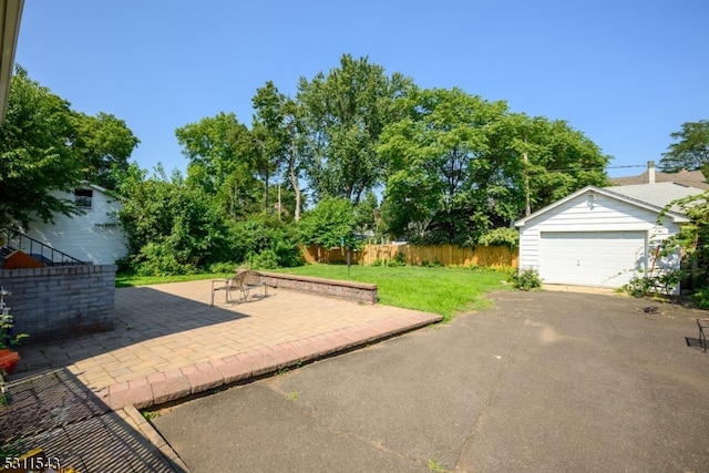 view of patio featuring a garage and an outbuilding