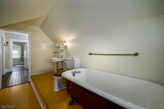 bathroom featuring vaulted ceiling, a bath, hardwood / wood-style floors, toilet, and sink