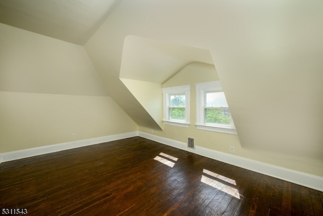 bonus room featuring vaulted ceiling and dark hardwood / wood-style floors