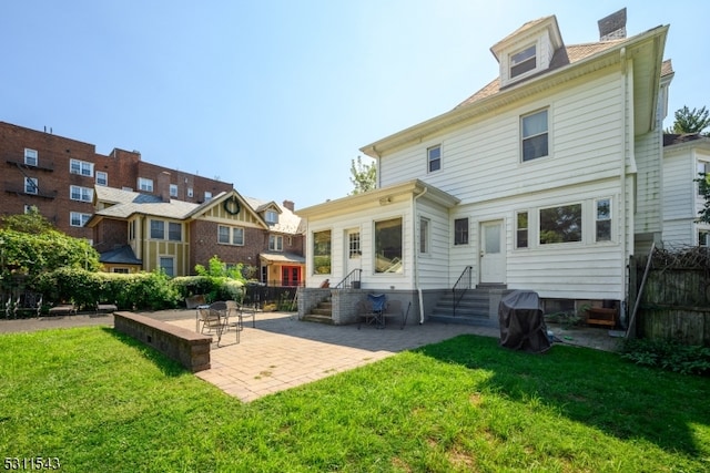 back of house with a lawn and a patio