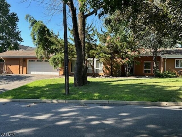 view of front of home with a front yard and a garage