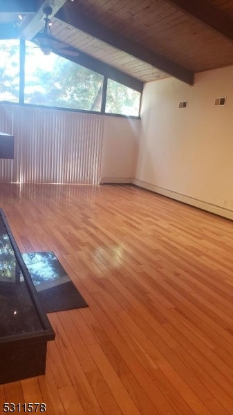 unfurnished living room with light hardwood / wood-style floors and lofted ceiling with beams