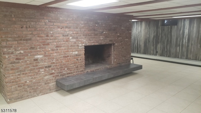 basement with baseboard heating, a brick fireplace, and brick wall