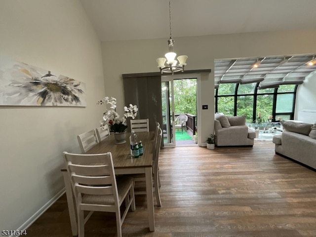 unfurnished dining area with vaulted ceiling, hardwood / wood-style flooring, and an inviting chandelier