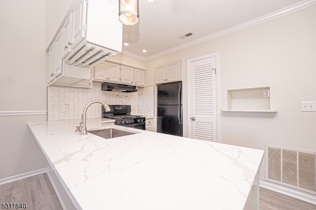 kitchen with black appliances, kitchen peninsula, white cabinetry, and light hardwood / wood-style flooring