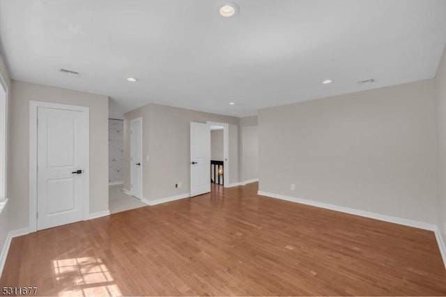 unfurnished room featuring visible vents, light wood-style flooring, and baseboards