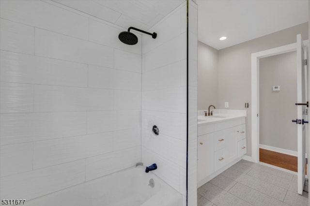 bathroom featuring tile patterned flooring, tiled shower / bath combo, and vanity