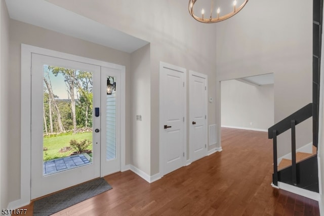 entryway featuring dark wood-type flooring and a chandelier