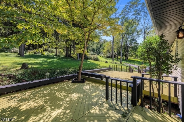 view of property's community featuring a lawn and a wooden deck