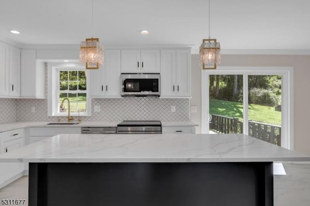 kitchen featuring white cabinets, a notable chandelier, stainless steel appliances, and a sink
