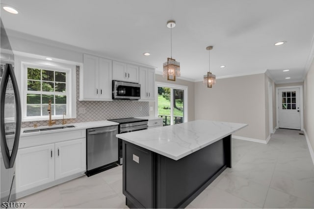 kitchen with hanging light fixtures, light stone countertops, appliances with stainless steel finishes, white cabinetry, and a kitchen island