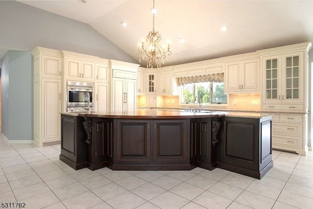 kitchen featuring paneled fridge, dark brown cabinets, a kitchen island, light tile patterned floors, and oven