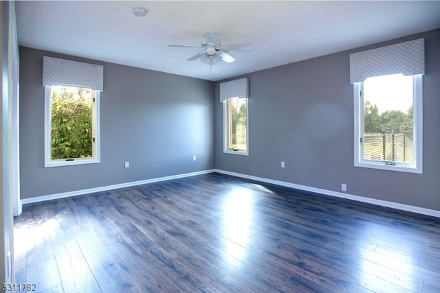 unfurnished room with ceiling fan, plenty of natural light, and dark wood-type flooring