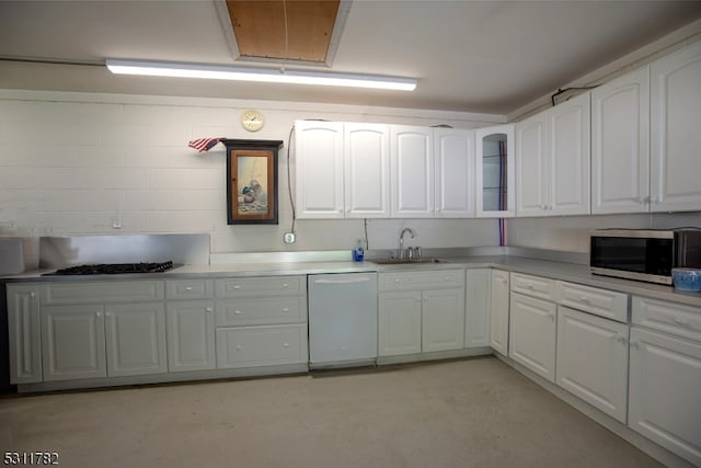 kitchen with dishwasher, gas stovetop, white cabinetry, and sink