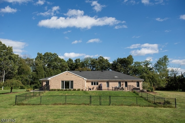 rear view of house with a lawn and a rural view